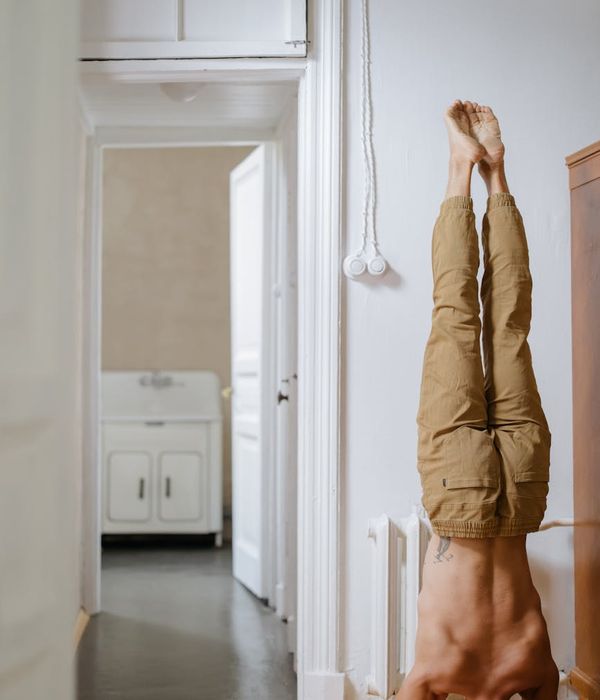 Man in a calm, focused pose, demonstrating balance and control in a softly lit room.